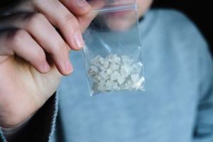 person holding crystal meth in bag seeking treatment help