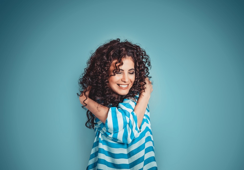 woman hugging herself and smiling