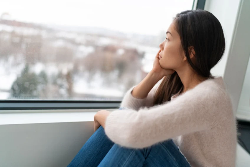 girl gazing out the window, coping with post-holiday blues