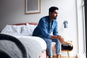 man resting in bed while managing comorbid depression and symptoms