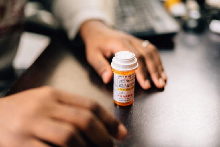 a man with a prescription oxycodone bottle