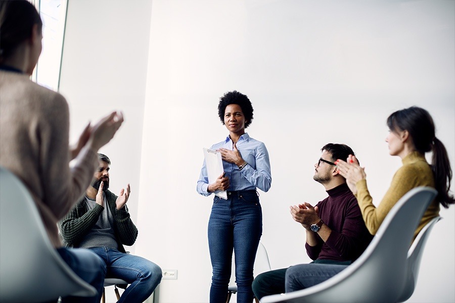 a woman speaking up in group therapy session