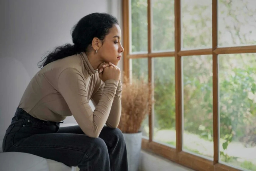 sad woman sitting at home, struggling with secondary traumatic stress