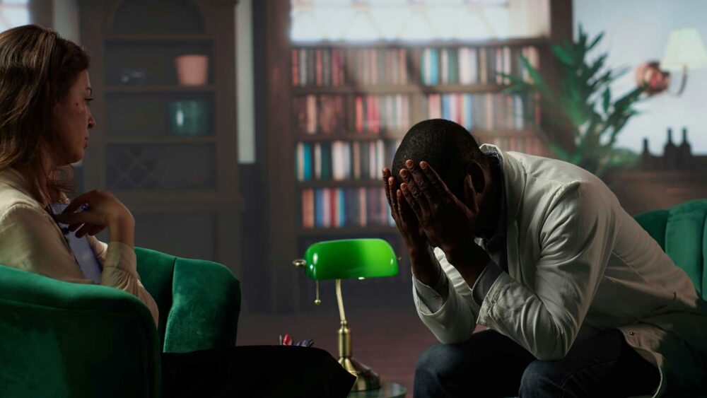 man with hands on his head in therapy, experiencing secondary traumatic stress