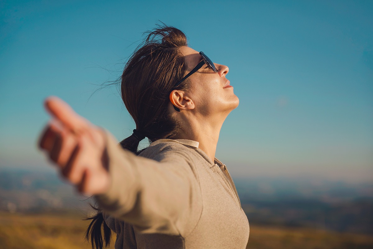 woman with arms out wide outside after addiction recovery