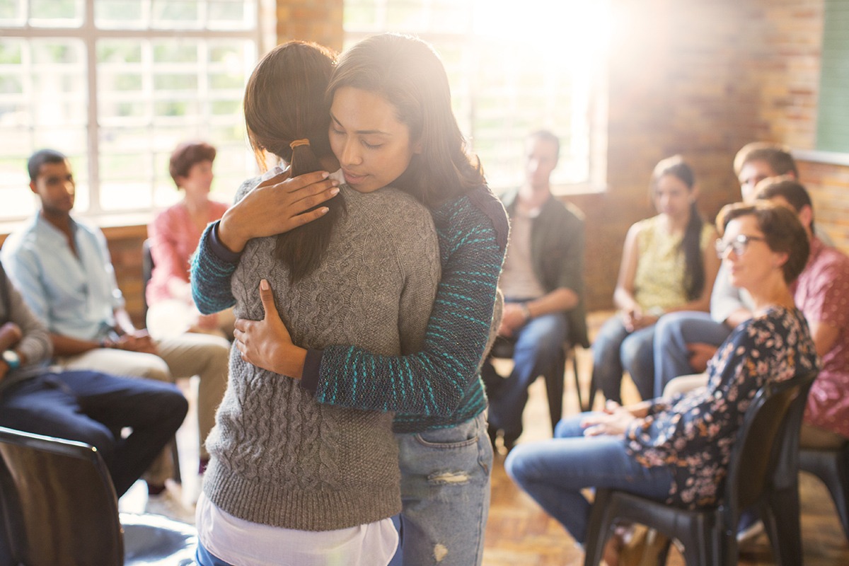 two people hugging after asking for help in recovery