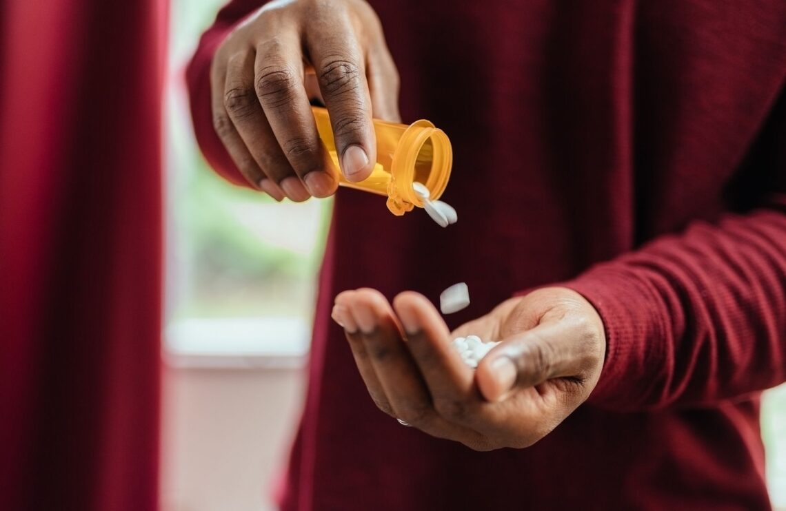 a man pouring opioids in his hand